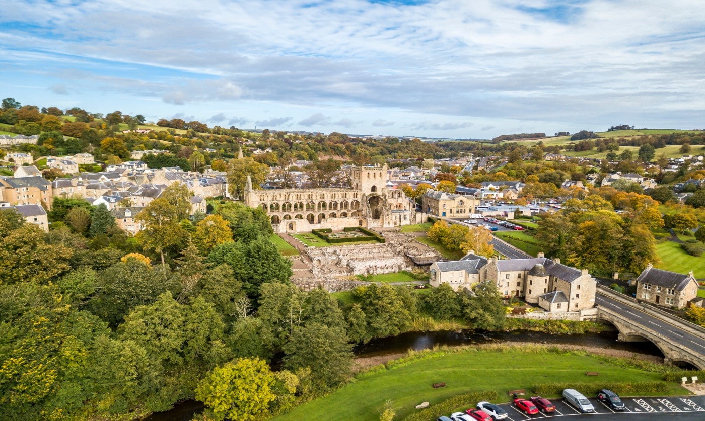 Aerial view of Jedburgh Abbey beside the Jed Water and Canongate Bridge